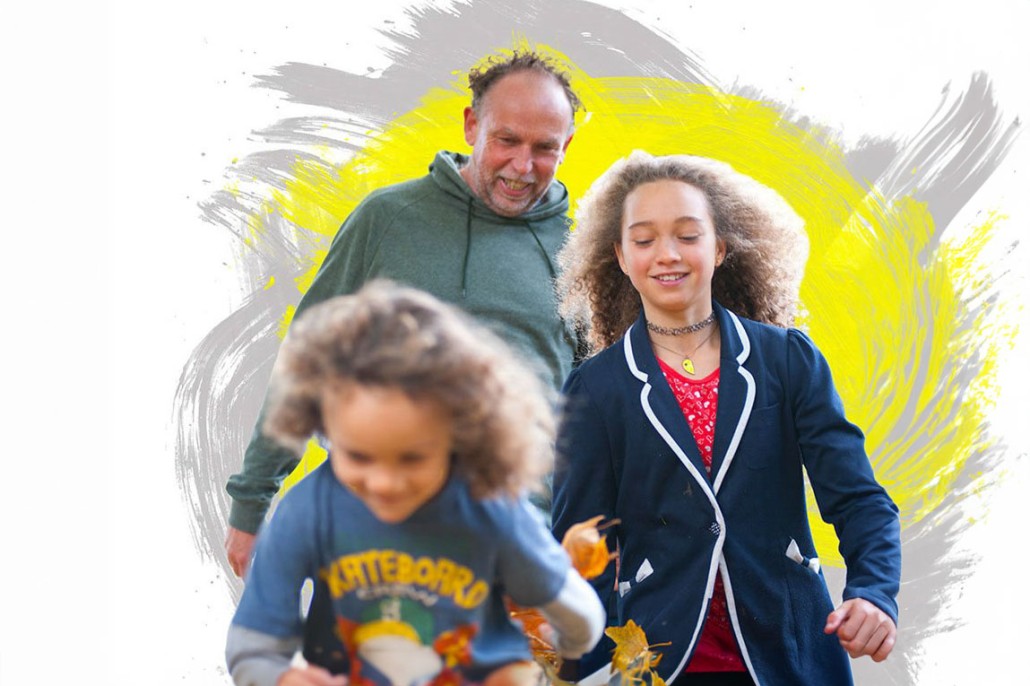 Image of a dad with his two children with a yellow and grey background.