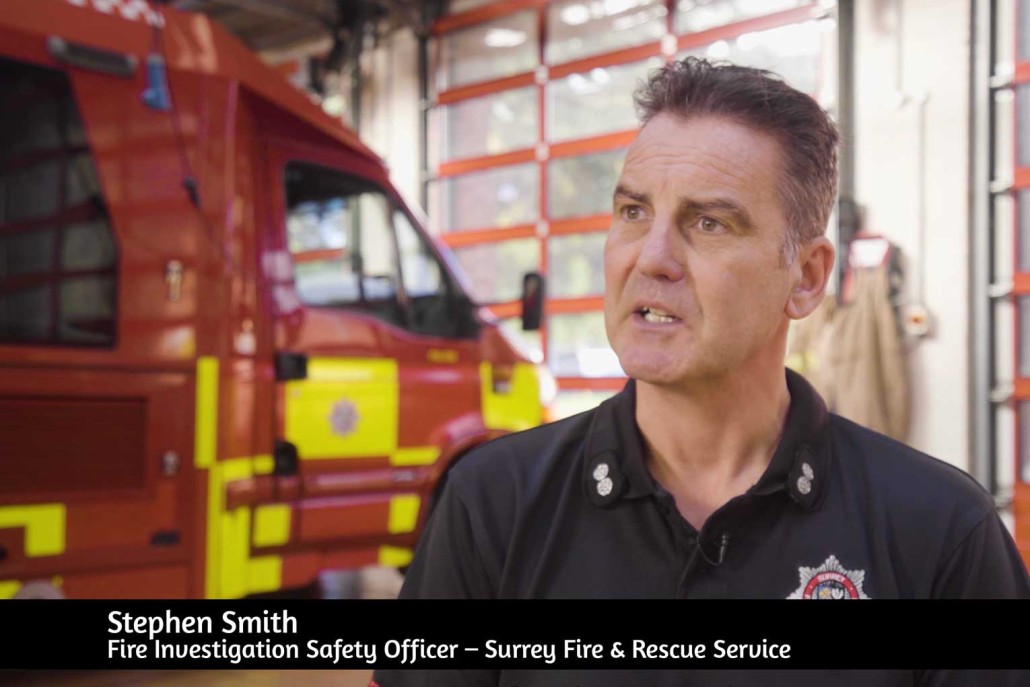 Still image of a fireman talking to the camera on set in the fire station.